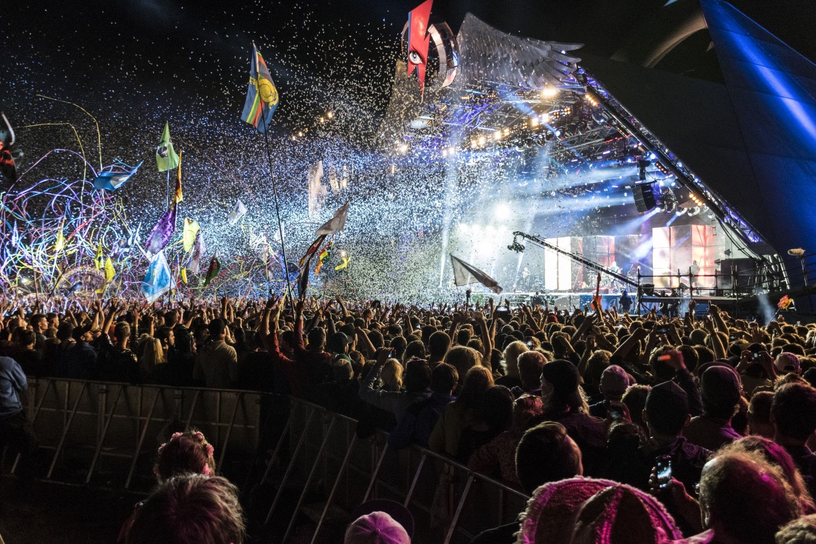 People watching a concert, with flags and streamers