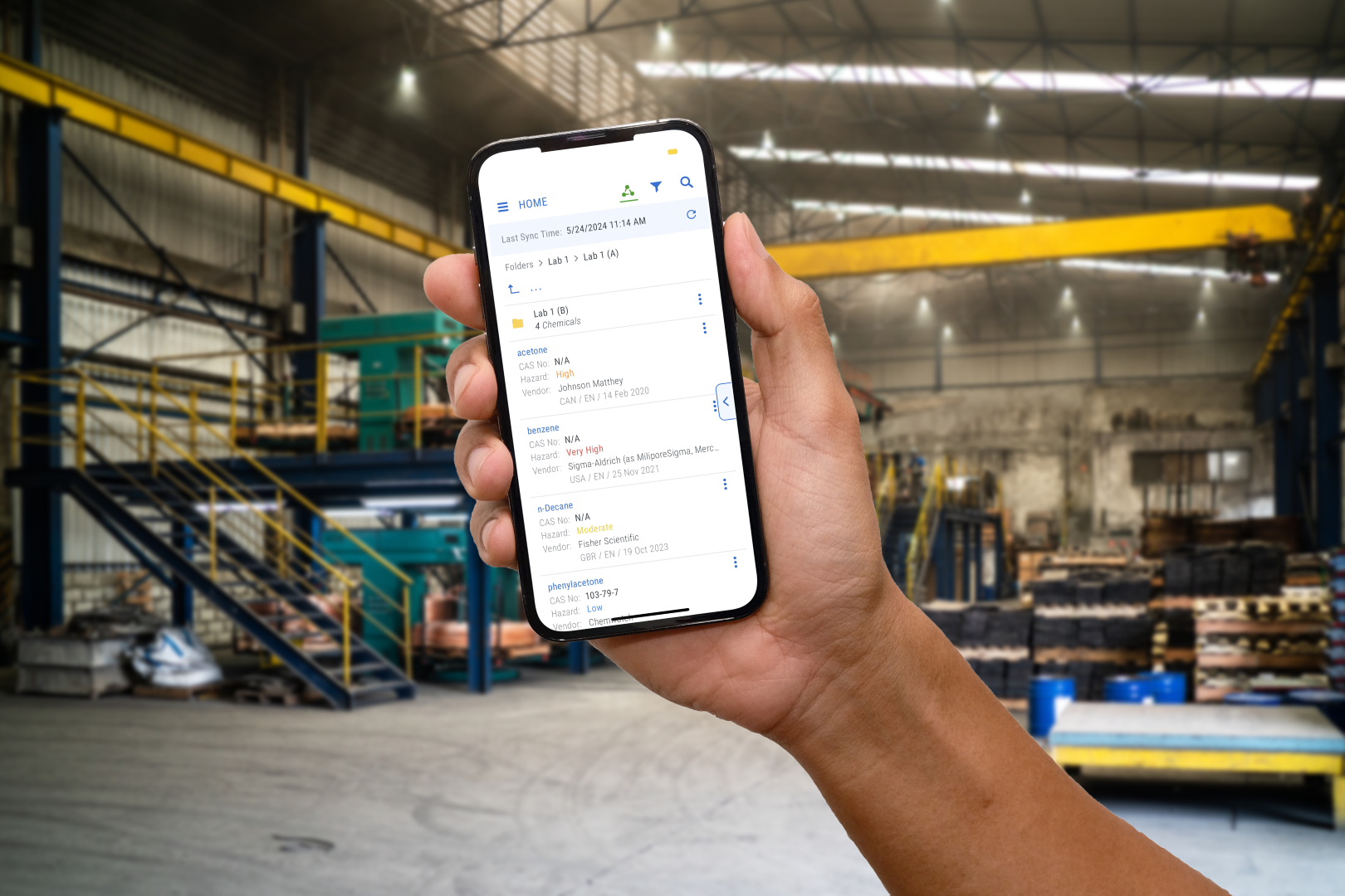 phone held in hand with screen on display in a factory 