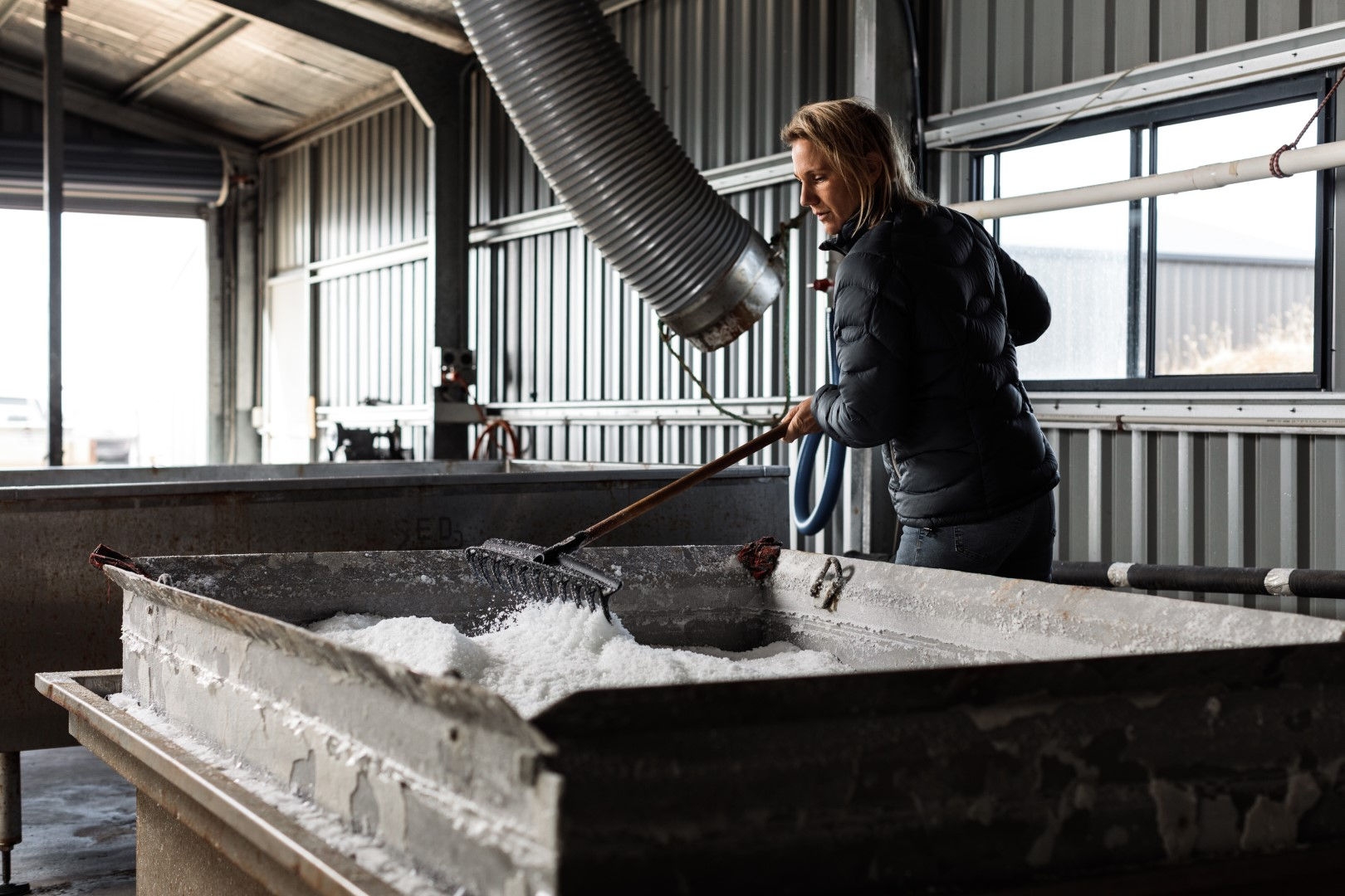 man working in a salt factory with pipe from roof