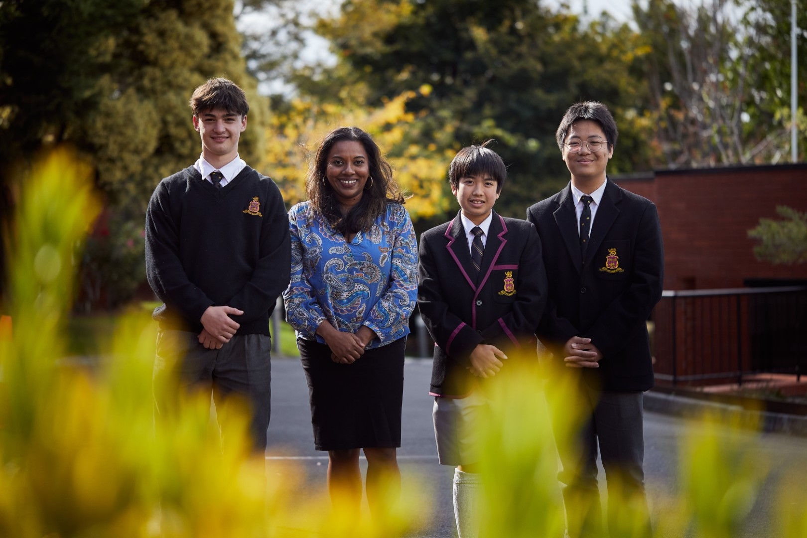 four students facing the camera smiling