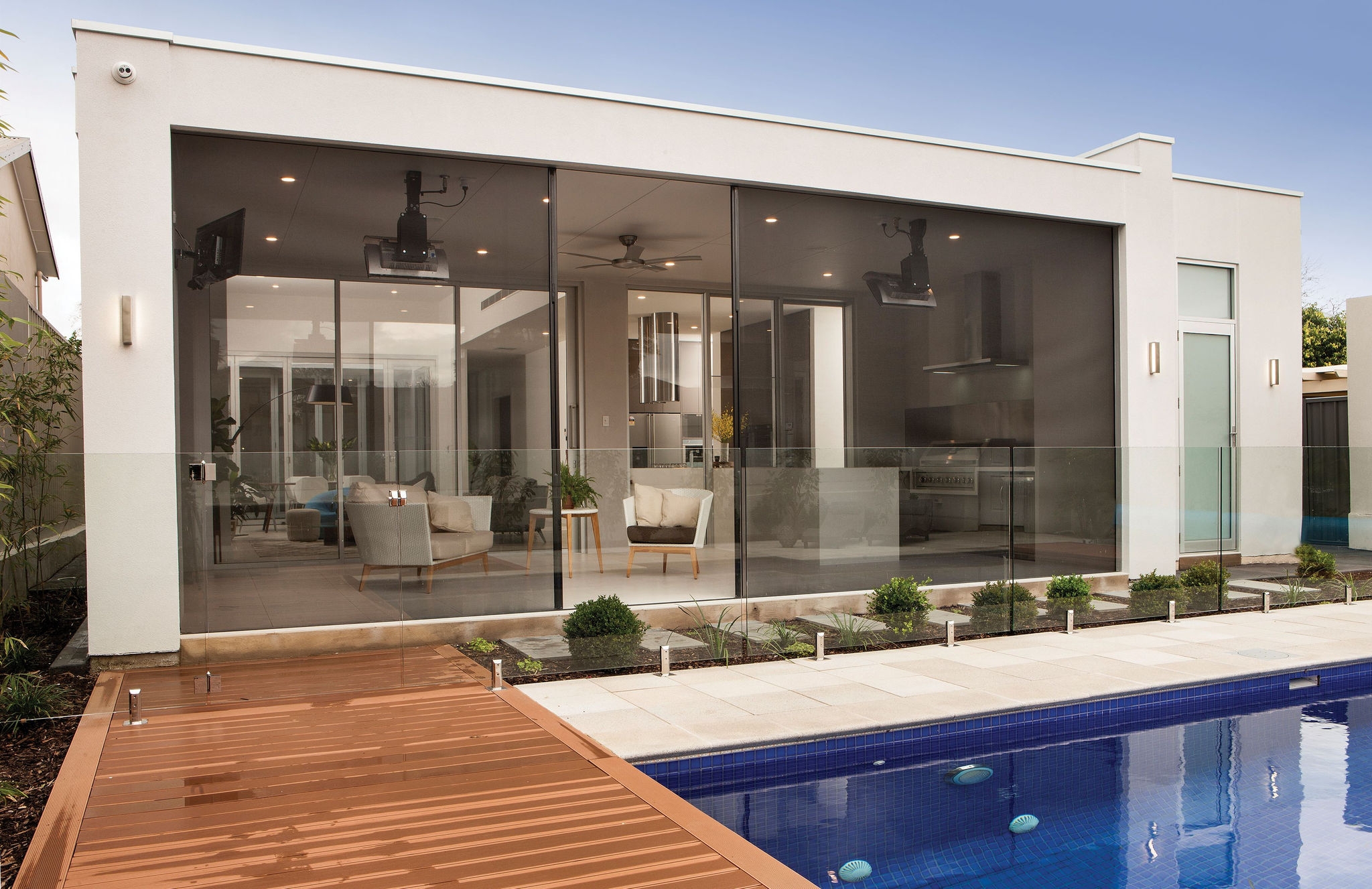 backyard of a white house with a pool and deck