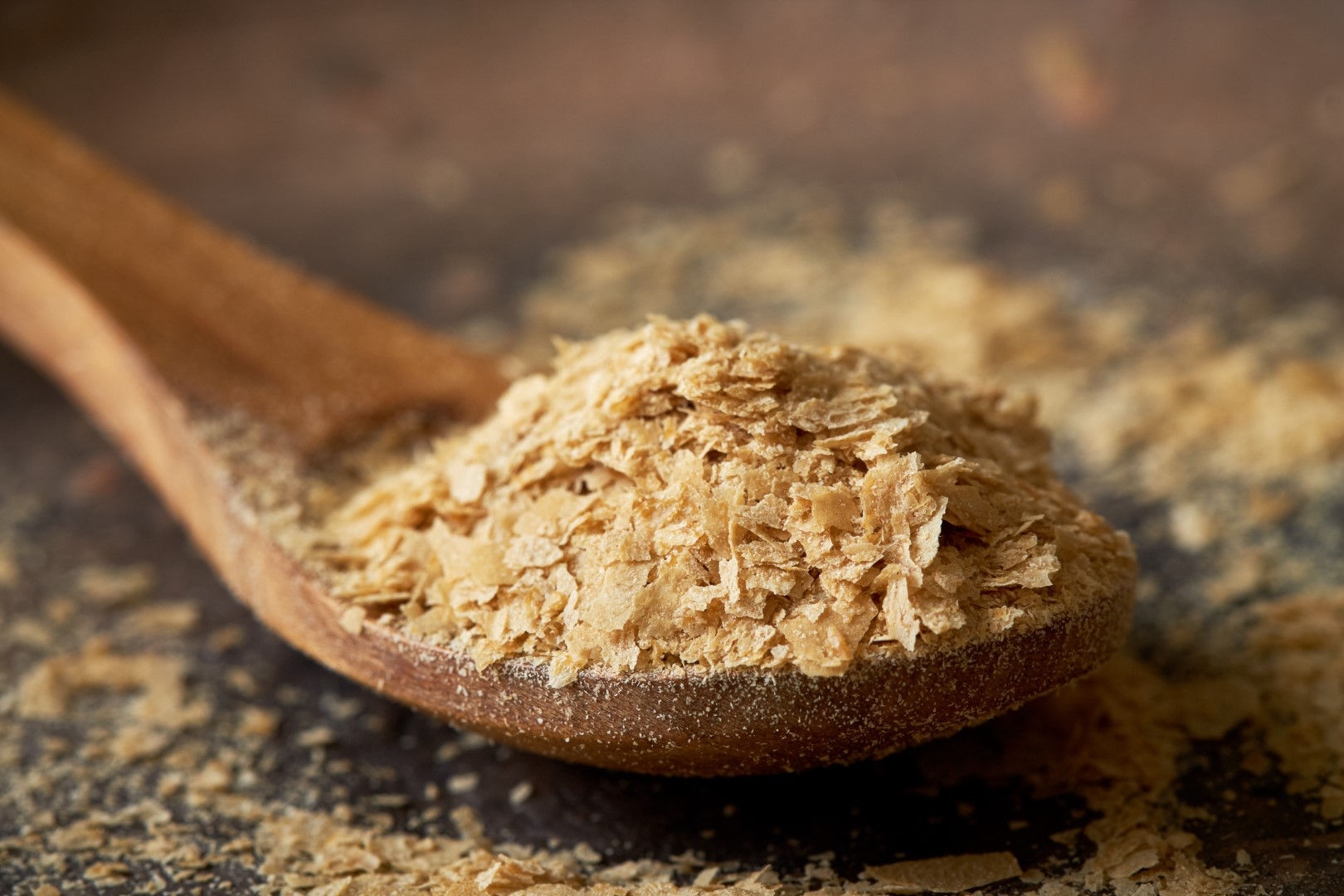 wooden spoon with golden colored flakes in spoon