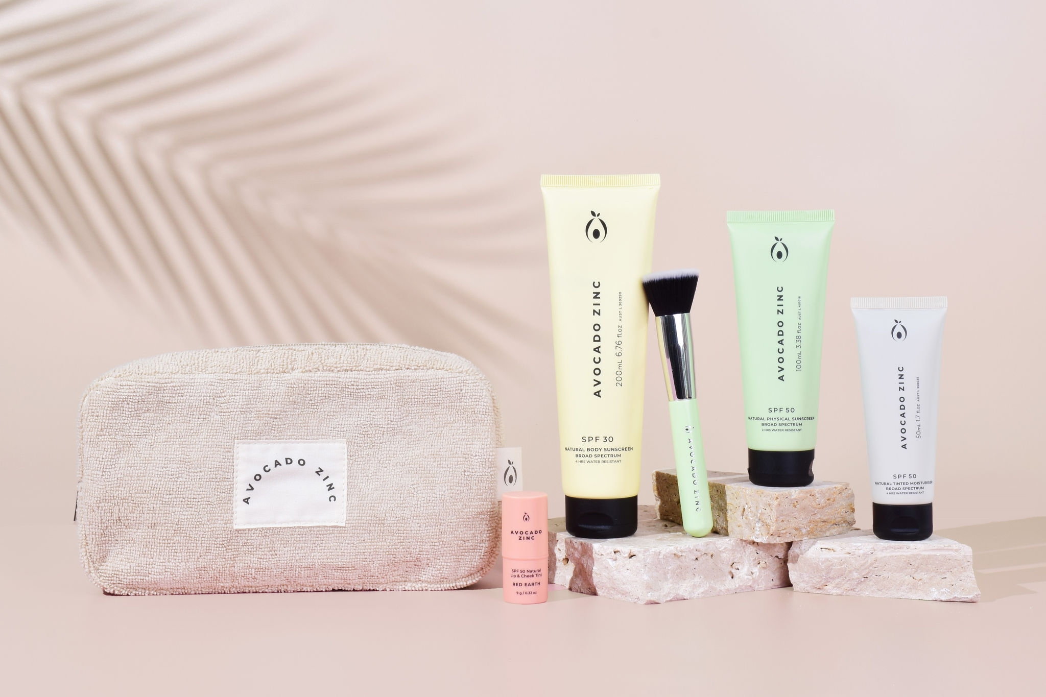 beauty products in pastel coloured packaging with a pastel bag and light pink background