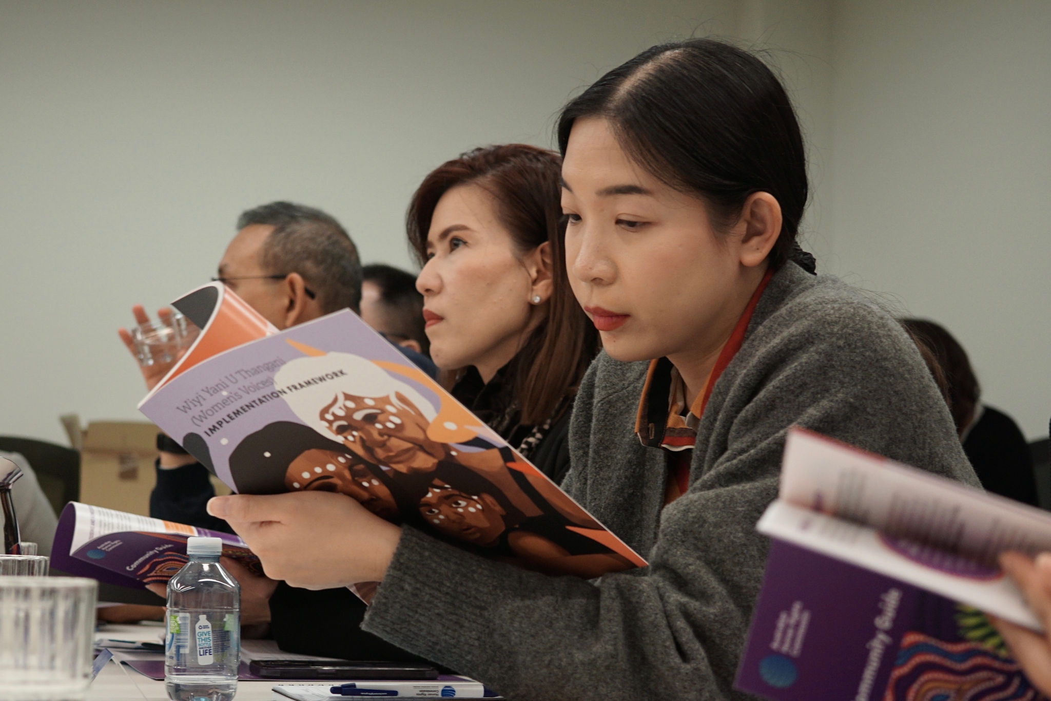 woman reading a booklet in a classroom