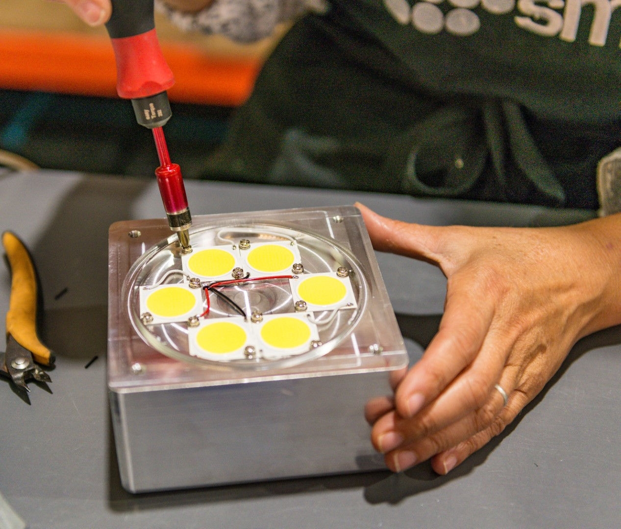 gadget on table with a persons hand holding gadget 