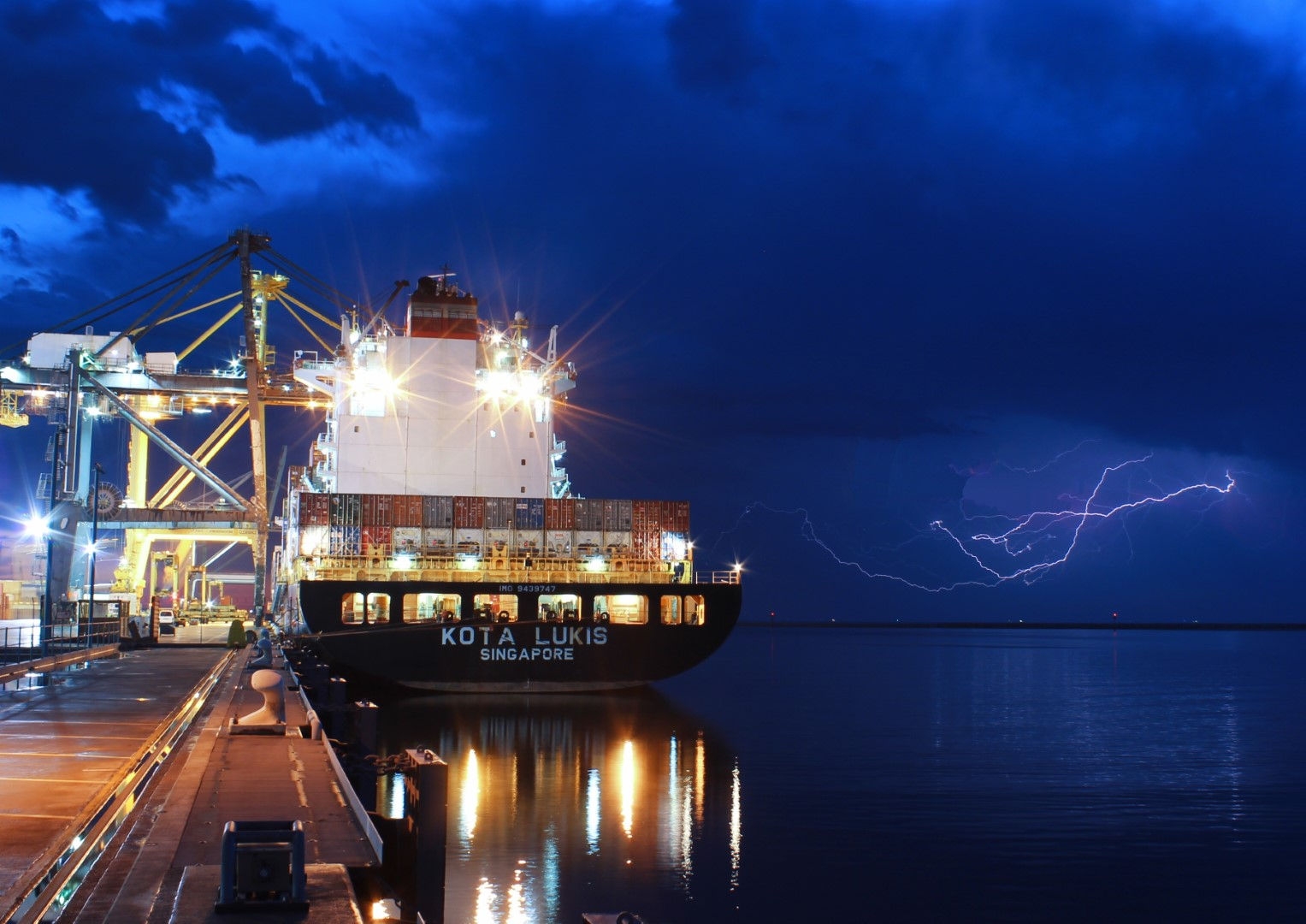 a ship in a port with a dark blue night background