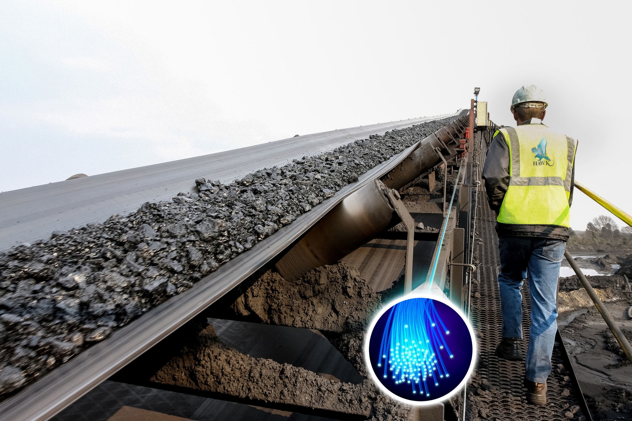 man in high vis standing next to a long rail of earthwork